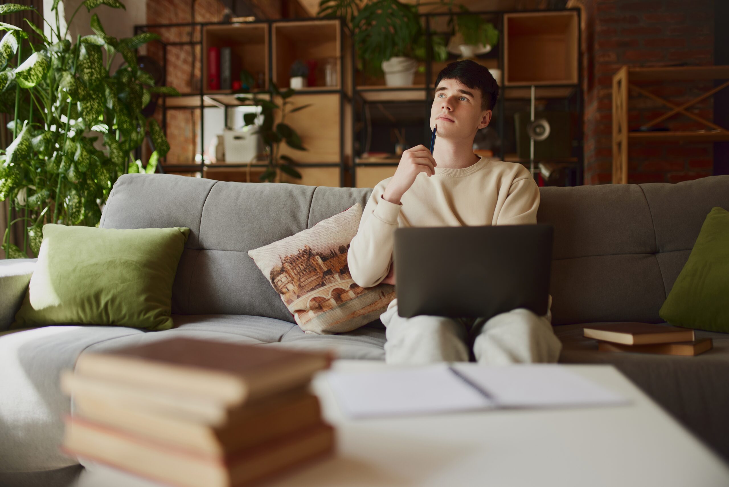 A man sits thoughtfully with a laptop, reflecting on embracing failure for growth.